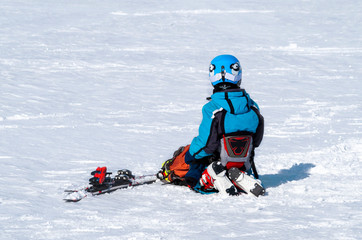 Fototapeta na wymiar The tired child fell off the ski and is on his knees looking into the distance.