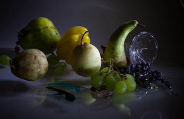 Still life with green and yellow fruit. beautiful fresh fruits in the dark