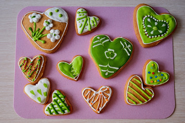 Childrens gingerbread handmade. Cakes with frosting for school party. Gingerbread with drawings in form of flowers and hearts. Cookies by hands of child. Top view a delicious Breakfast.