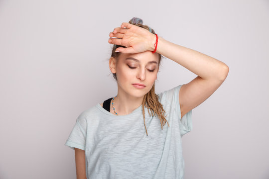 Woman with headache isolated over the grey studio