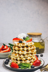 Stack of waffles with blueberries and strawberries