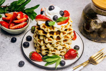 Stack of waffles with blueberries and strawberries