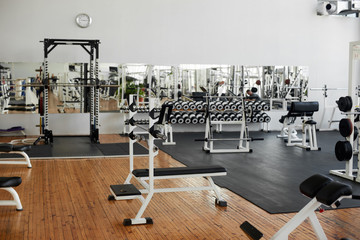 Fototapeta na wymiar Gym interior with equipment. Modern fitness center with training equipment. Commercial gym interior design.