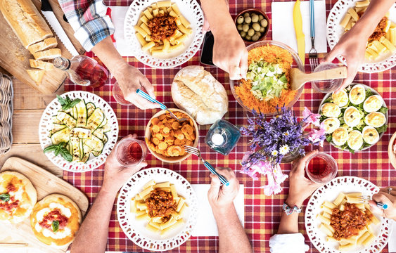 Four Adult People At Sunday Brunch With The Family. All Together Outdoor Toasting With A Rose Wine. Rustic Corner With Wooden Table And Checkered Tablecloth. Vegetables Food And Salad.