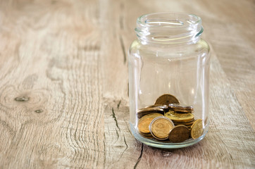 coins in a jar. Ukrainian pennies in a jar on a wooden background.