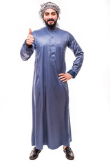 Young confident egypt man with thumbs up wearing white thobe isolated on a white background.