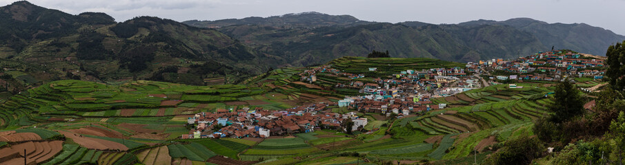 Panoramic View of a small village amidst terrace agriculture farms on the hills of Kodaikanal,...