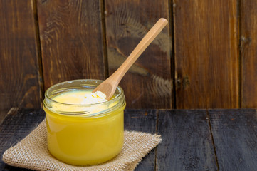Ghee butter or clarified butter on a wooden table, copy space
