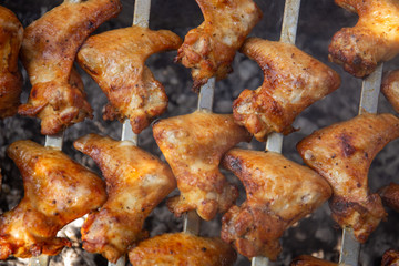 The concept of food on the grill. Chicken wings cooked on coals close up