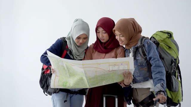Three hijab traveller holding a map find a holiday destination with white background