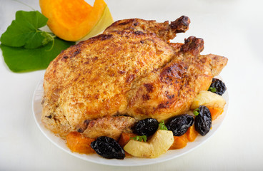 Roast Turkey, chicken, decorated with pumpkins, prunes, apples. thanksgiving day. slow food