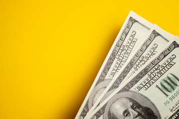 Dollar cash, banknotes on the yellow background.