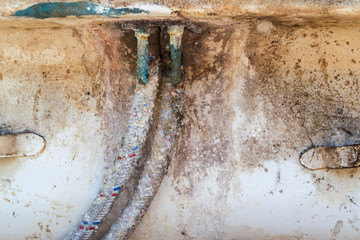 Old connecting pipes of a kitchen mixer close-up.