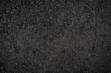 Texture of dark smooth asphalt with small stones. Wallpaper for design, top view.