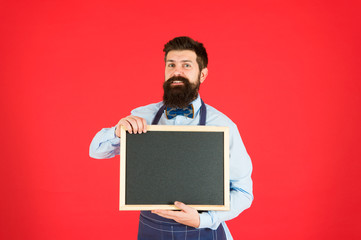 Bar advertisement. Hipster bartender show blackboard copy space. Hipster restaurant staff. Hipster informing you. Man bearded bartender or cook apron hold blank chalkboard. Vacant positions concept