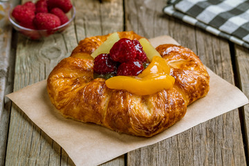 Danish with berries on wooden background