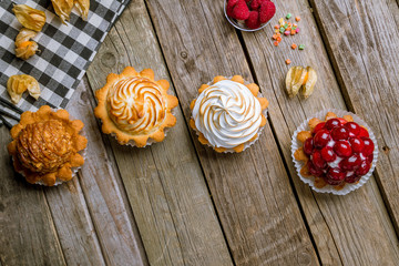 tartlets with fresh berries and lemon on wooden board