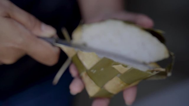 hand preparing rice cake or ketupat for eid mubarak celebration