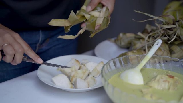 hand preparing rice cake or ketupat for eid mubarak celebration