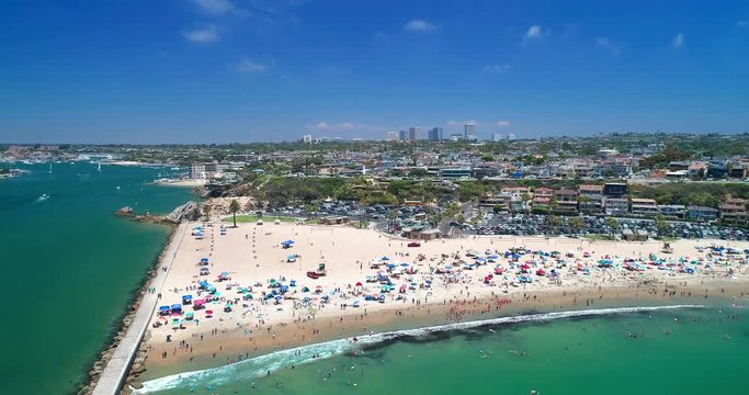 Aerial view over beach in Corona Del Mar in Orange County California on a sunny blue sky Summer day with people enjoy holiday.