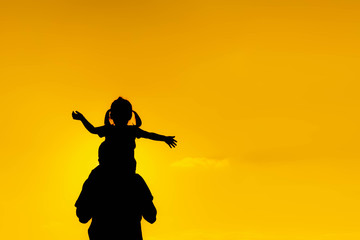 Fototapeta na wymiar The family silhouette of the mother and child standing watch the sunset and the sky in orange in evening