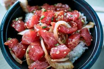 A bowl of delicious Poke, one of the main dishes of native Hawaiian cuisine served with diced raw fish and vegetables.