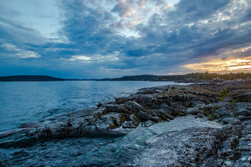 Karelia. Russia. Sunset on lake Ladoga. Ladoga skerries. The waves of Ladoga wash the rocky shore. Northern nature of Karelia. Travelling to Russia.