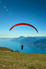 Paraglider flying over the Garda Lake,Panorama of the gorgeous Garda lake surrounded by mountains, Malcesine,Italy