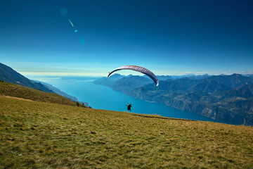 Paraglider flying over the Garda Lake,Panorama of the gorgeous Garda lake surrounded by mountains,...