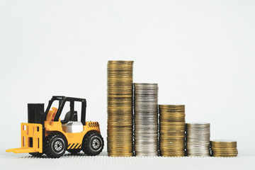 Mini forklift truck with coin stack, business finance and banking industrial concept. © pookpiik