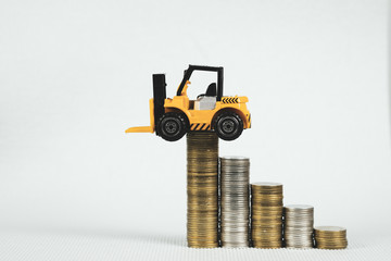 Mini forklift truck with coin stack, business finance and banking industrial concept.