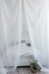 Fototapeta na wymiar White large canopy bed on top
