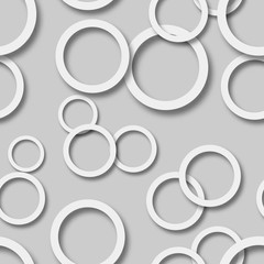 Abstract seamless pattern of randomly arranged white rings with soft shadows on gray background