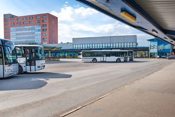 Buses parked near platforms with shelters at bus station