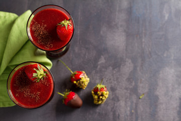 Chocolate strawberry smoothie and chocolate covered berries with chopped pistachios. Healthy drink. View from above, top studio shot