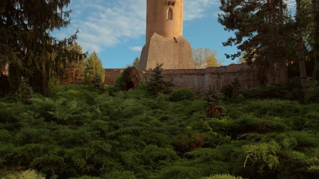 Golden hour sunset view of the medieval Chindia Tower in the Transylvanian town of Targoviste surrounded by beautiful vegetation