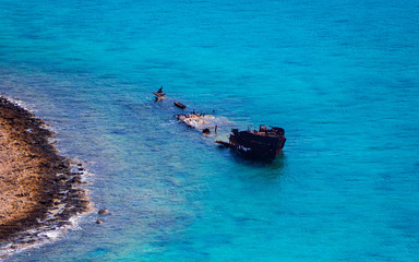 Sunken ship in the shallow blue water
