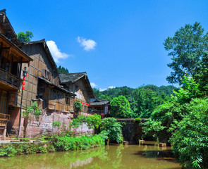 Fototapeta na wymiar Blue sky, green mountains and woods, rivers, buildings along the river, Chinese town