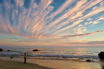 Couché de soleil irréel avec les nuages qui forment des lignes roses
