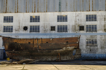 Abandoned wooden ship hull on the side of a shipyard