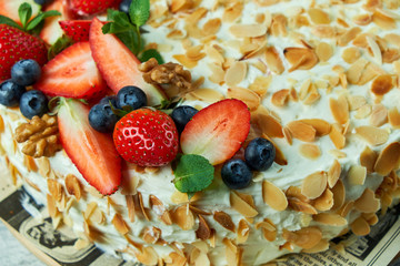 Strawberry meringue cake with almond petals, on newspaper 