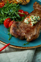Steak with vegetables and salad, with roasted garlic