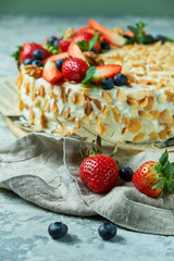 Strawberry meringue cake with almond petals, on newspaper 