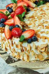 Strawberry meringue cake with almond petals, on newspaper 