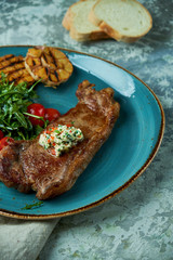 Steak with vegetables and salad, with roasted garlic