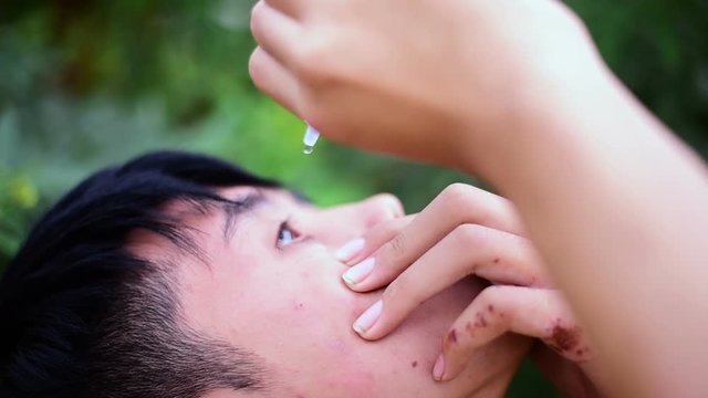 Boy dropping eye drop medicine healing his eye pain, health care eye medicine concept