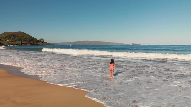 Girl on Beach Staring into the Water Drone Shot - Ocean Waves Crashing as She Walks