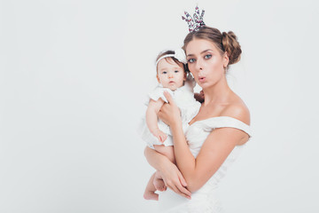 baby in the arms of the mother. on white background Woman holding a child. Fashion for girl. Queen...