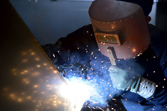 Arc welding work at a back street factory in Japan: Welding while protecting with handle welding mask