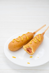 Two corn dogs on white plate